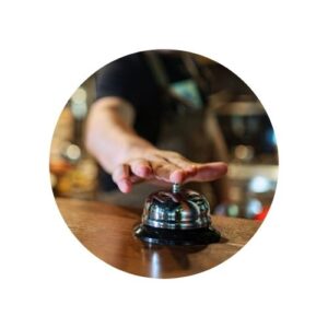 Plan serré, main prête à sonner au comptoir.